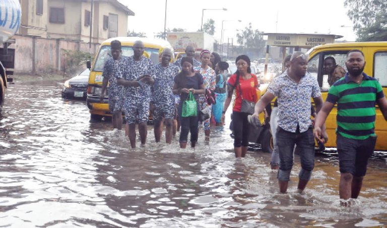 People-wade-through-flood-along-Agege-Ogba-road-in-Lagos-yesterday